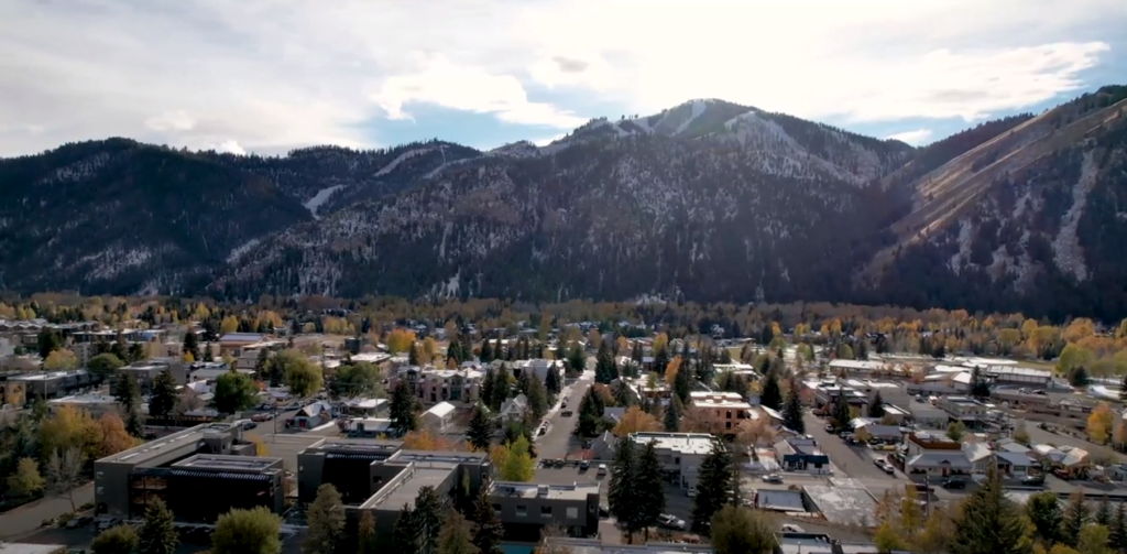 A view of a town with visible mountains and sky from above