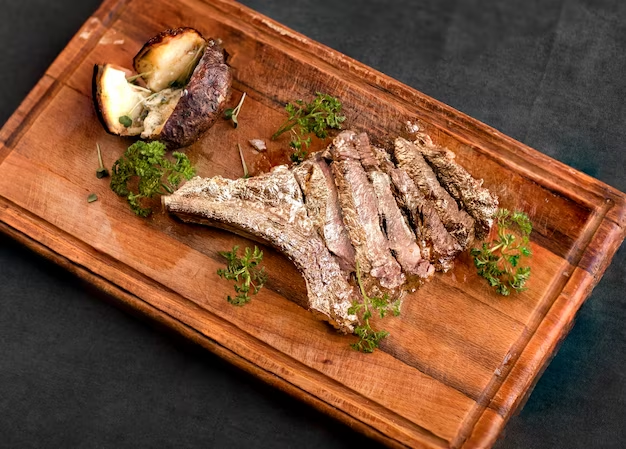 Steak on wooden board with herbs around