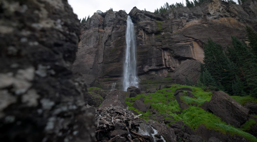 waterfall and the mountains, trees below it