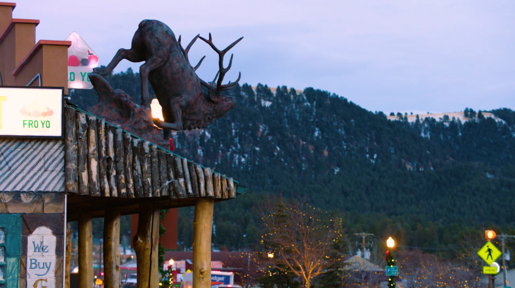 deer on the building, tree with decoration and hills with trees on it