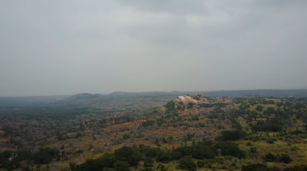 the landscape with hills and trees on it