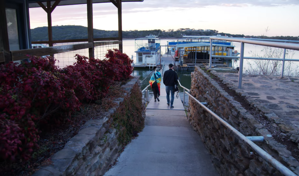 a man and a woman walk along the asphalt path to the ship